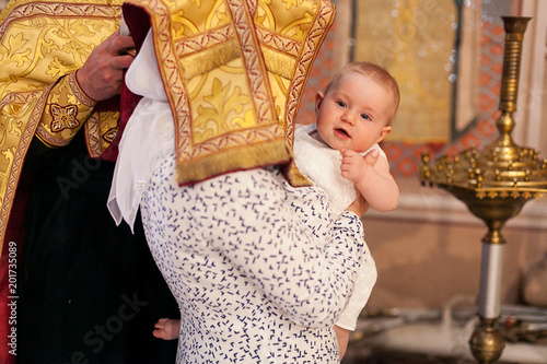 Epiphany ceremony. Mother with covered head holding baby girl