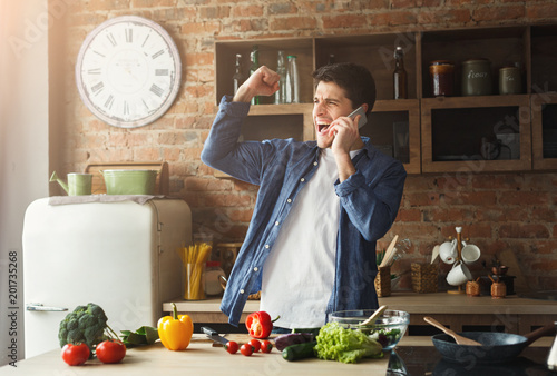 Happy man preparing healthy food in the home kitchen