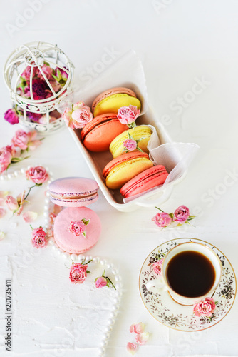 Dessert: A Delicate Fresh Colorful French Macaroons In Pastel Colors With Flowers Roses On A Light Textile Background, Top View