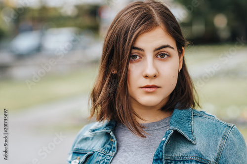 Valokuva Outdoor portrait of young teenage 16 year old girl, wearing denim jacket