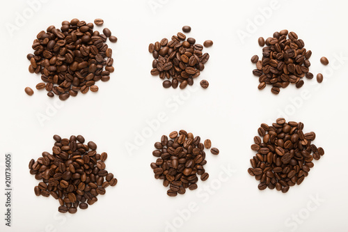 Heaps of brown coffee beans isolated on white
