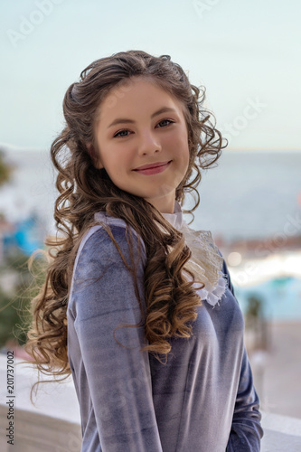 portrait of a smiling sly naughty girl with curlers in an old retro dress