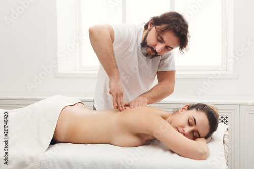 Male masseur doing professional body massage