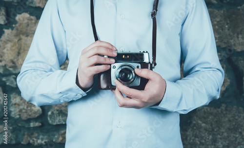 Hands holding retro camera.