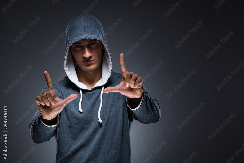 Young man wearing hoodie pressing virtual buttons Young man wearing hoodie pressing virtual buttons