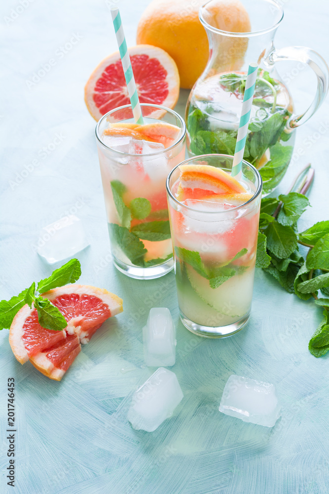 Refreshment grapefruit cocktail with mint on mint color background. Healthy citrus summer drink. Refreshment grapefruit cocktail with mint on mint color background. Healthy citrus summer drink.