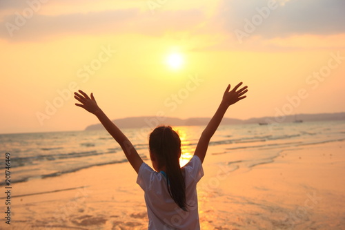 Happy girl at the beach, sunset shot, rear view,Kid relaxing at the beach with arms open enjoying,For background.