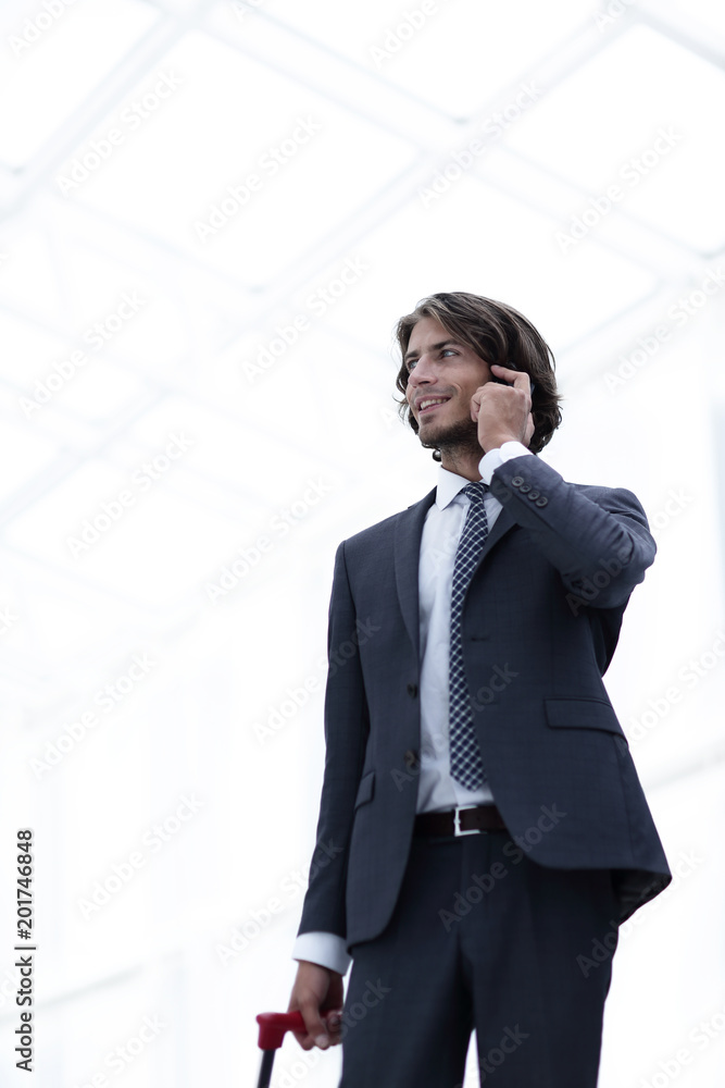 bottom view.businessman with Luggage talking on a cell bottom view.businessman with Luggage talking on a cell