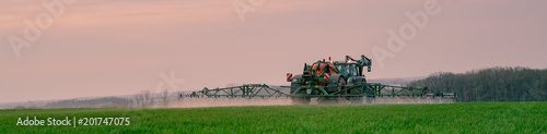 Ackerbau - Landwirt bei Pflanzenschutzmaßnahmen im Getreide am Abend, Banner