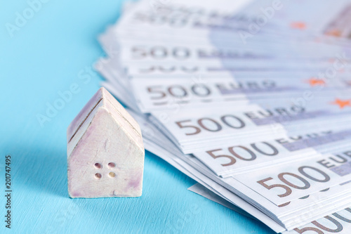 The concept of a toy house on a background of banknotes of 500 euros