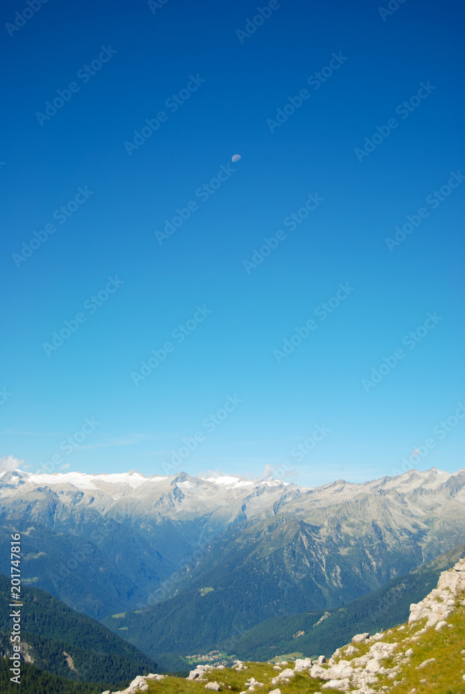 Moon among the Adamello mountains Dolomites