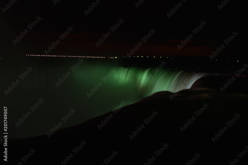 Colorful illuminated Niagara Waterfalls at night in Ontario, Canada