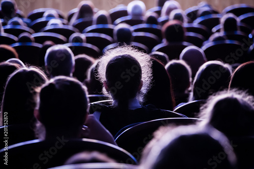 Spectators in the theater or in the cinema. Children and adults. Full house.