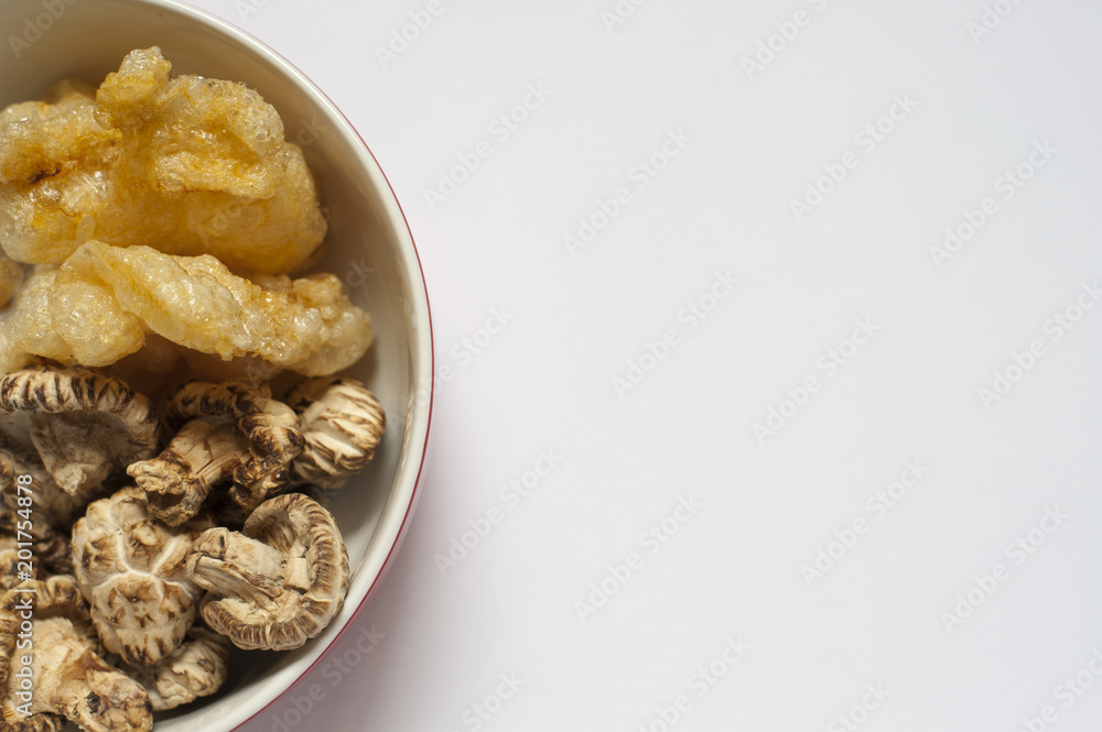 A close-up shot of some dried fish maw and mushrooms in a kitchen, these ingredient are in preparation stage A close-up shot of some dried fish maw and mushrooms in a kitchen, these ingredient are in preparation stage