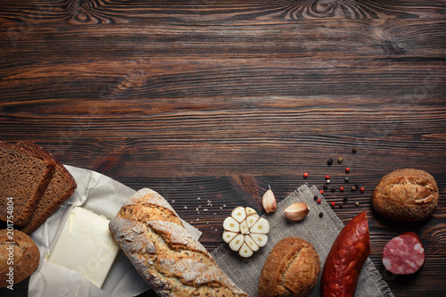 Garlic, bread , sausage on old wood background