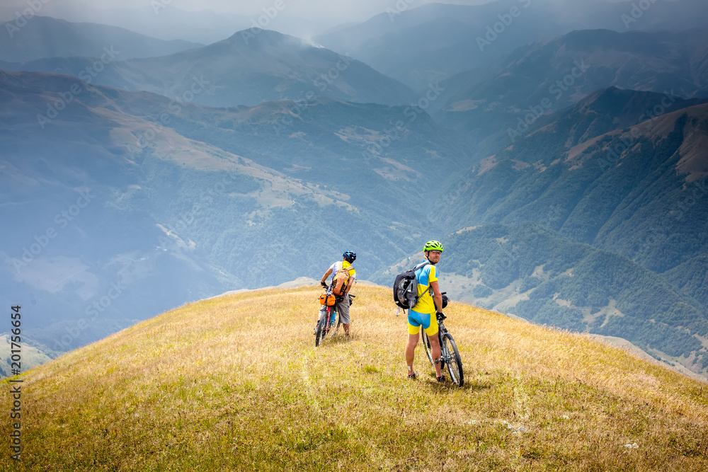 Cyclists rest in the mountains while biking Cyclists rest in the mountains while biking