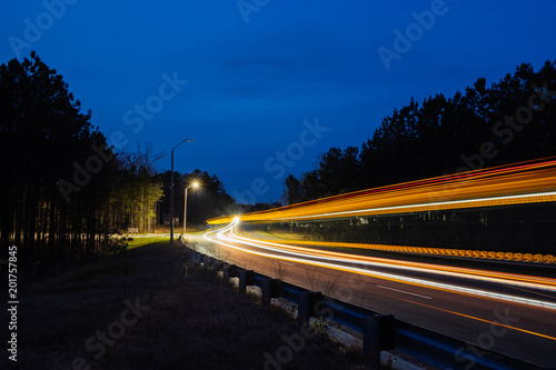 Tableau sur toile Motion blur of bus on city street at dusk