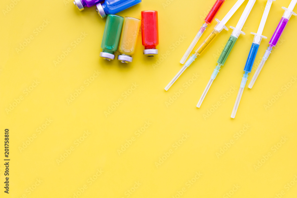 Medical injection Syringe and bottle with remedy on yellow background top view copy space Medical injection Syringe and bottle with remedy on yellow background top view copy space
