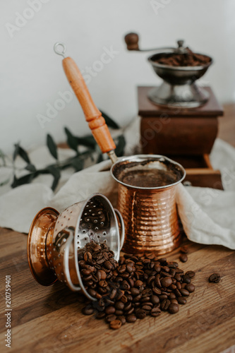 Turkish coffee pot, coffee mill and olive brunch on linen napkin. rustic trendy background.