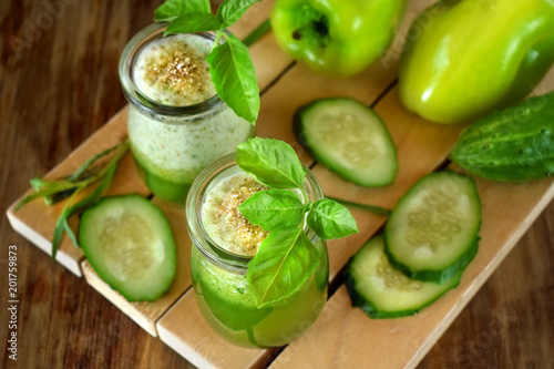 Green smoothie in a glass jar sprinkled with brans decorated with basil