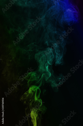 Multi-colored smoke on a black background. Tubers of smoke of different colors rise up.
