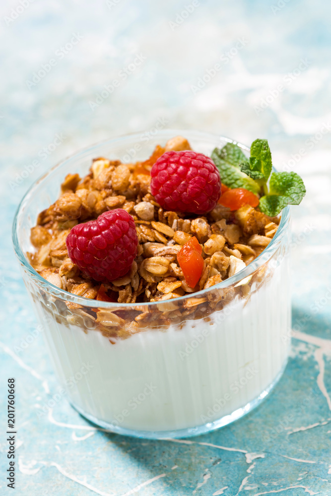 sweet dessert with granola, raspberry and natural yoghurt, vertical sweet dessert with granola, raspberry and natural yoghurt, vertical