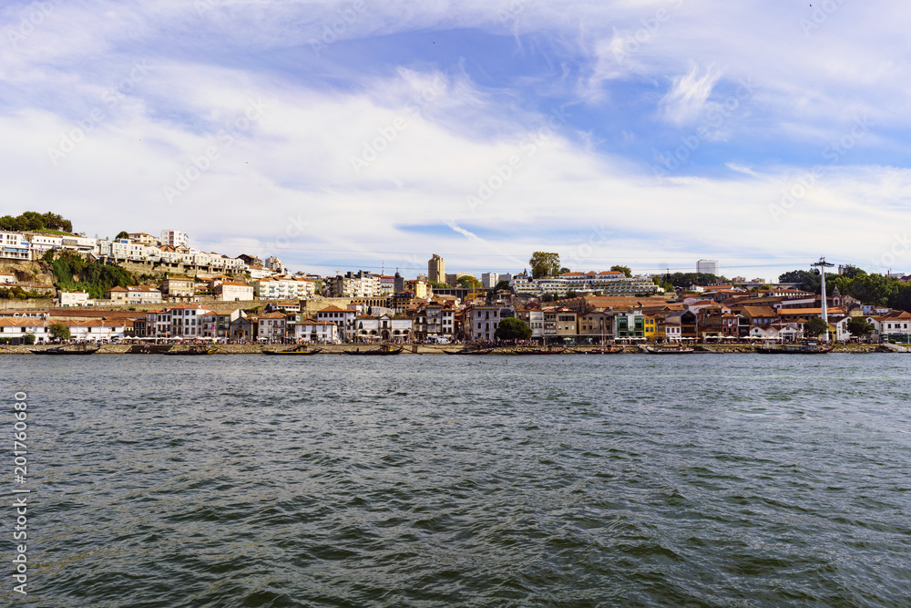 Porto, Portugal. August 12, 2017: panoramic view of the south bank of the Douro River estuary with the facades of the wineries that are on its banks with a sky with few very beautiful clouds