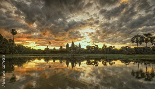 Beautiful Cambodia ancient temple complex Angror Wat at sunrise with dramatic clouds over the towers and reflection in the pond. Very famous travel destination. 
