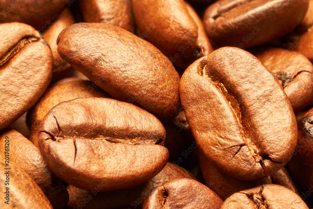 Large roasted coffee beans of golden color close-up. Macro photography. The texture of the roasted coffee beans. Bright abstract background ideal for any design Large roasted coffee beans of golden color close-up. Macro photography. The texture of the roasted coffee beans. Bright abstract background ideal for any design
