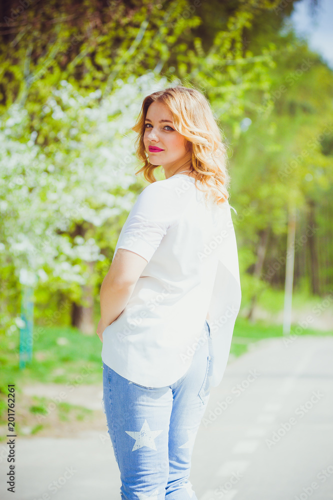 Beautiful blonde pregnant woman walking in the green garden Beautiful blonde pregnant woman walking in the green garden
