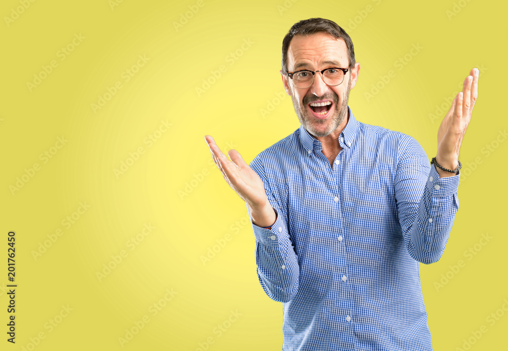 Handsome middle age man confident and happy with a big natural smile welcome gesture Handsome middle age man confident and happy with a big natural smile welcome gesture