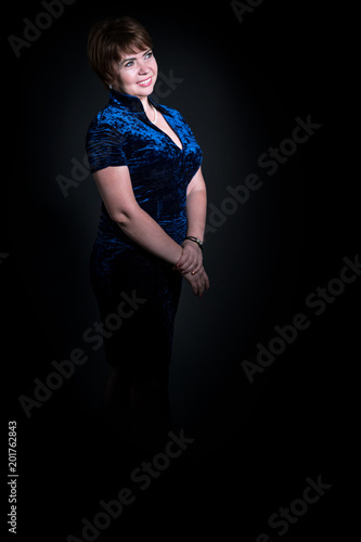 Full-length portrait of a middle-aged woman on a black background