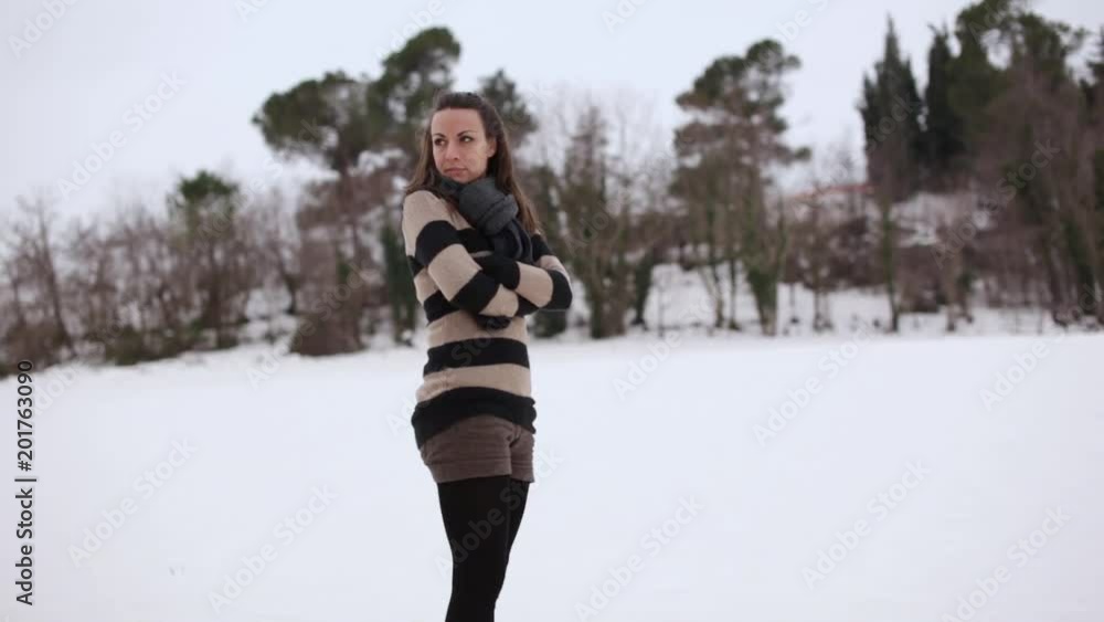 Young woman with a brown dress looking around in a snowy environment Young woman with a brown dress looking around in a snowy environment