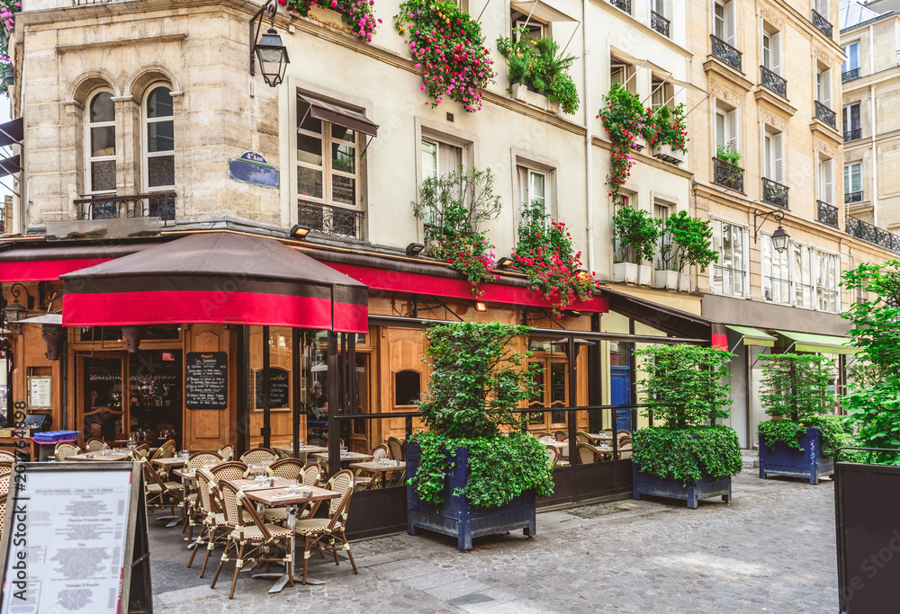 Fototapeta premium Typowy widok na paryskiej ulicy ze stołami Brasserie (kawiarnia) w Paryżu, Francja