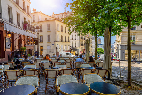 Cozy street with tables of cafe in quarter Montmartre in Paris, France