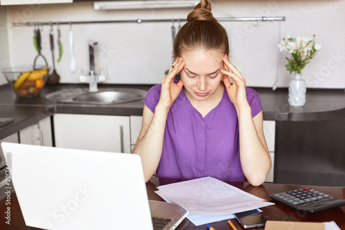 Photos Overworked young female businesswoman has headache after sleepless night, works