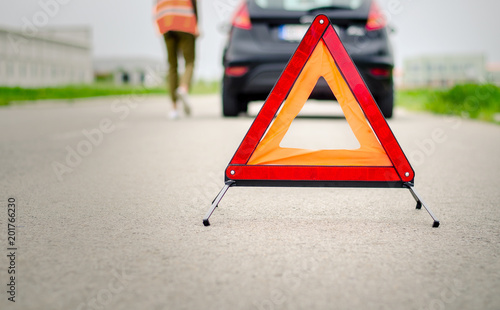 Trouble with car on the road, red triangle, safety jacket