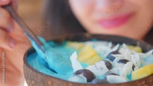 woman showing blue majik, spirulina superfood smoothie coconut bowl  photo