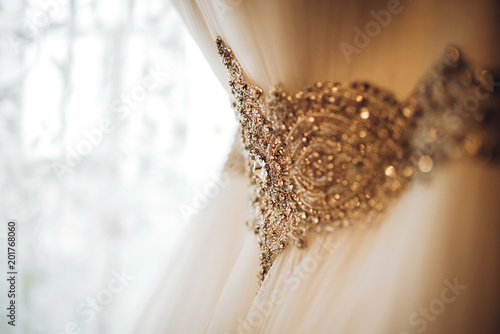 Pretty white wedding dress hang in the bride’s room