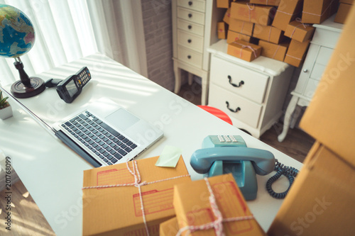 Packaging on the table with laptop and telephone.