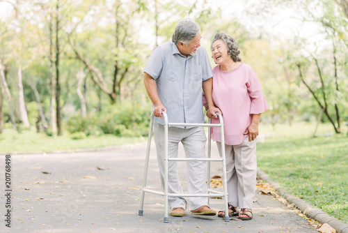 Foto Happy senior couple talking a walk with walker