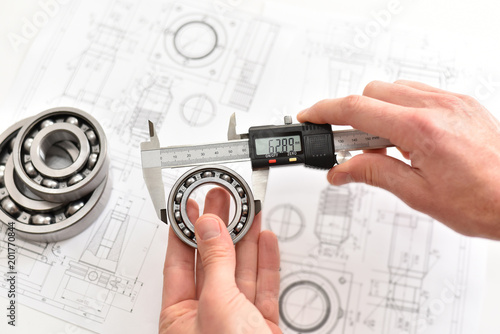 Qualitätskontrolle im Maschinenbau - meßen mit einem elektronischem Messschieber von einem Kugellager in der Fertigung // Quality control in mechanical engineering - measuring with caliper gauge