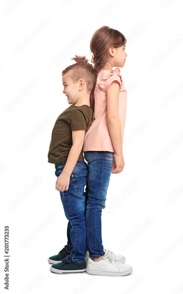Little children measuring and comparing their height on white background Little children measuring and comparing their height on white background