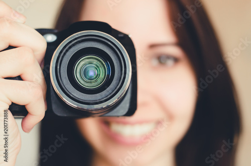 Young smiling brunette girl with camera photo