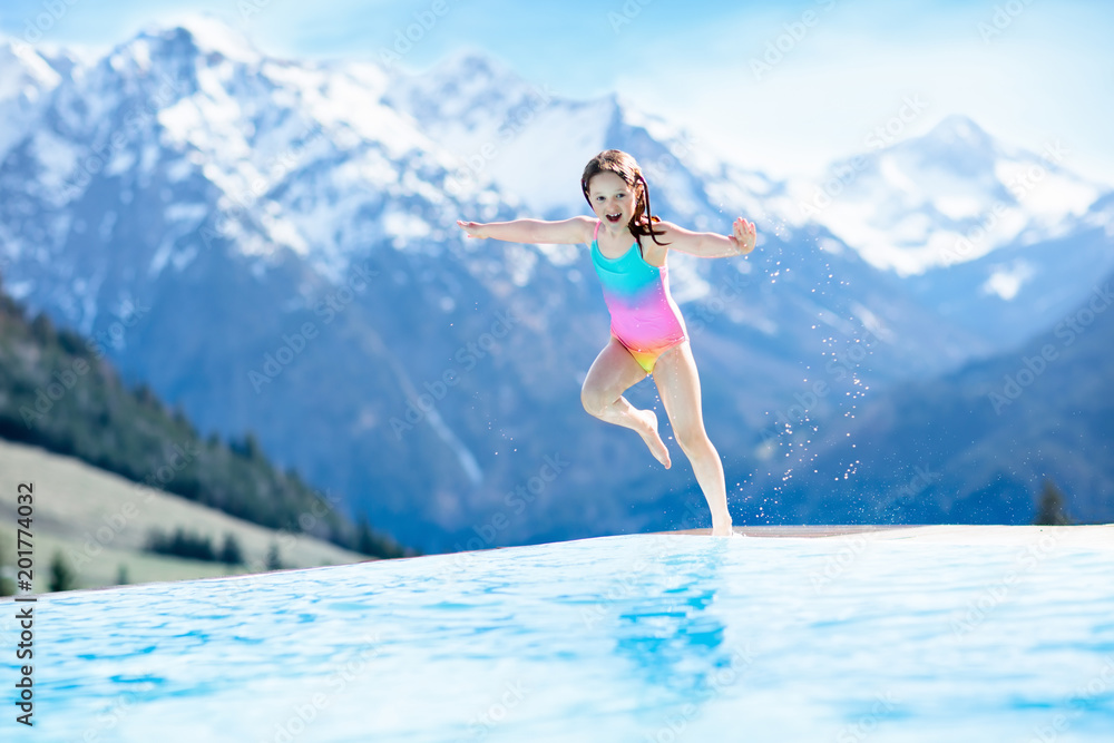 Child in outdoor swimming pool of alpine resort Child in outdoor swimming pool of alpine resort