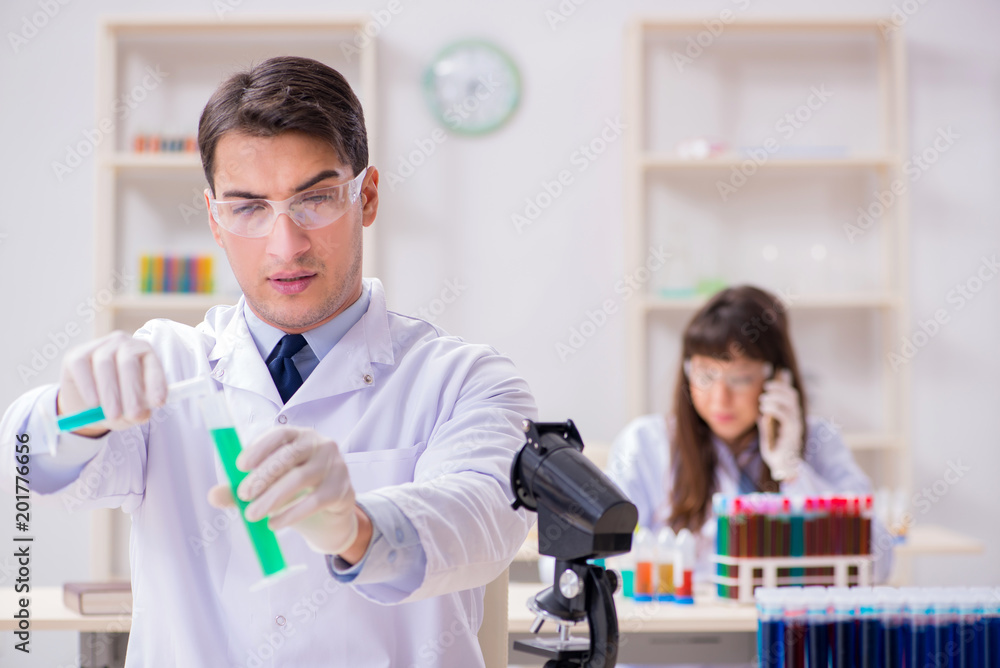 Two chemists working in lab experimenting Two chemists working in lab experimenting