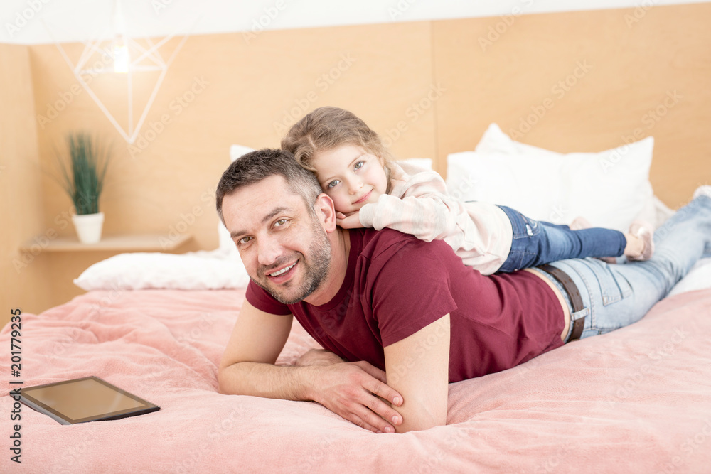 Happy childhood. Cheerful little girl smiling and having fun with her daddy Happy childhood. Cheerful little girl smiling and having fun with her daddy