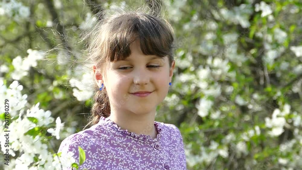 Young girl near beautiful flowering tree. Flowering garden in spring. Beautiful girl holding a branch and flowers in her hands. Young girl near beautiful flowering tree. Flowering garden in spring. Beautiful girl holding a branch and flowers in her hands.