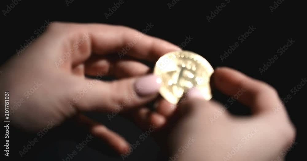 Woman Holding Bitcoin Coin in Hands. Dark On Background Woman Holding Bitcoin Coin in Hands. Dark On Background