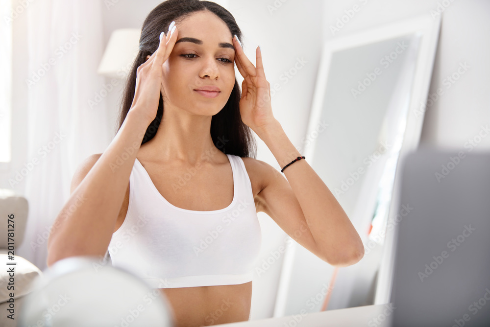 Diligent student. Pleasant slim watching facial massage tutorial and rubbing the skin of her forehead, following the steps thoroughly Diligent student. Pleasant slim watching facial massage tutorial and rubbing the skin of her forehead, following the steps thoroughly